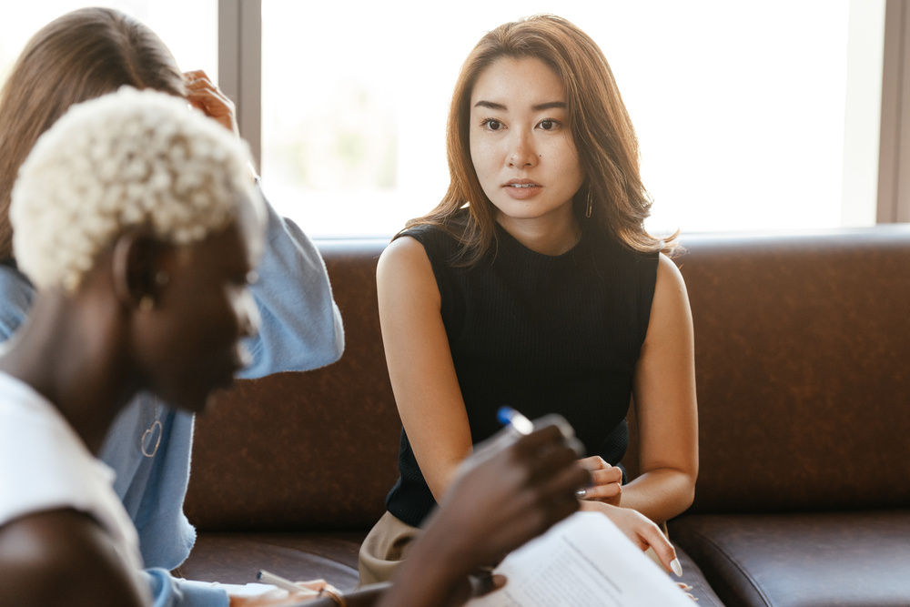 Young Asian woman explaining business strategy to colleague